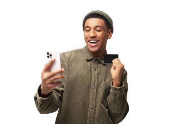 Neşeli Orta Doğulu adam online alışveriş için akıllı telefon ve kredi kartı kullanıyor. Mutlu adam internetten yemek sipariş ediyor. Erkek, uzun zamandır beklenen cep telefonunun parasını ödüyor.