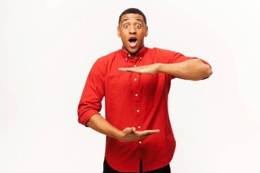 Aferikan asıllı Amerikalı genç adam avuç içi boşluğu ölçüyor. Tepeden tırnağa boyut gösteriyor. Kırmızı tişörtlü adam reklam yeniliği yapıyor.