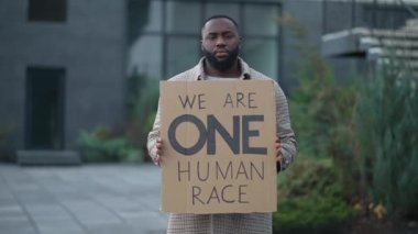Kendine güvenen ciddi bir Afrikalı Amerikalı dövüşçü dışarıda duruyor ve üzerinde anti-tiryaki yazılar var.