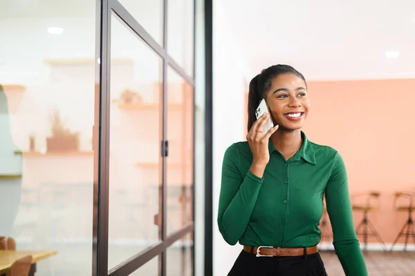 Confident African American Businesswoman Talks Phone Walking Office Hall Cheerful — Stockfoto