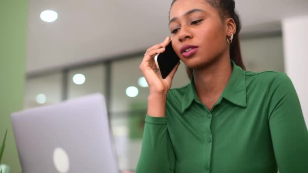 Urocza Młoda Afroamerykanka Korzystająca Laptopa Miejscu Pracy Rozmawiająca Przez Telefon — Wideo stockowe
