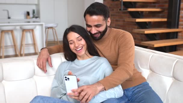 Positive Indian Couple Love Spends Time Together Home Using Smartphone — Vídeo de Stock