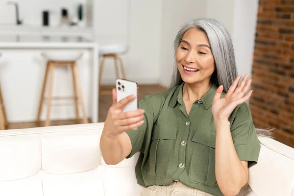 Starší Žena Držící Mobilní Telefon Mávající Rukou Šťastná Usměvavá Dospělá — Stock fotografie