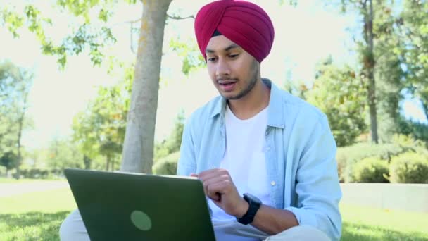 Smiling Friendly Male Freelancer Wearing National Headwrap Using Laptop Video — ストック動画