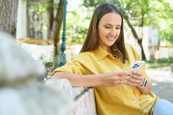 Portrait Attractive Young Woman Wearing Yellow Shirt Texting Smartphone Sitting — Zdjęcie stockowe