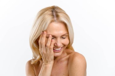 Huzurlu ve kaygısız orta yaşlı yarı çıplak bir kadın beyaza izole edilmiş bir şekilde gülüyor. Bencil bakım kavramı