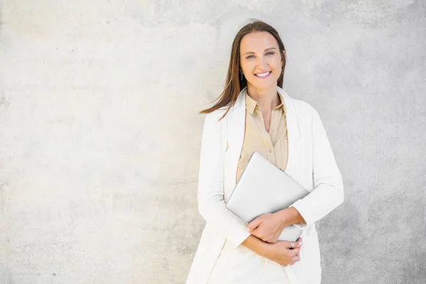 Charismatic Smiling Positive Businesswoman Stands Laptop Computer Gray Wall Confident — ストック写真