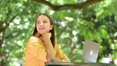 Açık havada dizüstü bilgisayar kullanan özgür bir kadın. Yazlık kafede oturup e-postalarına cevap veren kaygısız genç bir kadın.