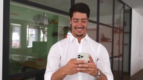 Positive Hispanic Male Employee Using Smartphone Online Communication Smiling Businessman – stockvideo