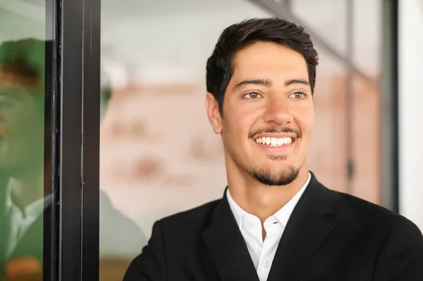 Close-up headshot portrait of successful masculine latin businessman in formal expensive suit indoors, smiling proud male entrepreneur, ceo, manager