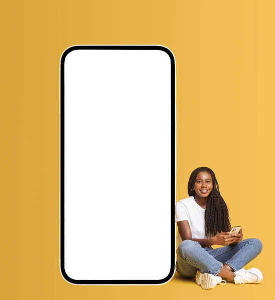 Africká Americká Žena Sedí Poblíž Obrovského Smartphonu Prázdnou Prázdnou Obrazovkou — Stock fotografie