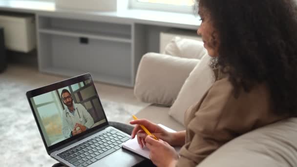 医師とのビデオ会議 オンラインビデオ相談 スマートフォンの画面上のインドの男性医師は 治療をお勧めします ビデオ接続を介して若い女性に治療をお勧めします テレメディシンの概念 — ストック動画