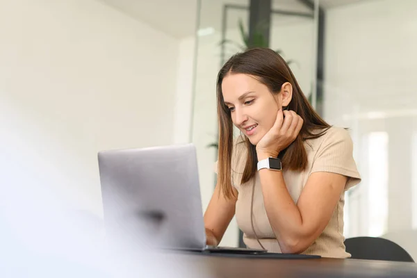 若い白人女性の肖像ノートパソコンで机の上に座って 電子メールを入力します メッセージの友人 チャット 日付快適な笑顔でオンライン 長距離関係の概念 — ストック写真