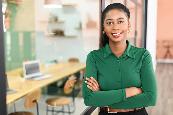 Ambitious female entrepreneur ceo manager stands in contemporary office space with arms crossed leaned on glass partition, smiling businesswoman looks at camera