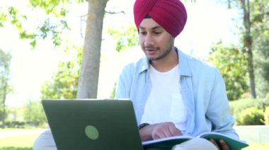 Sanal Webinar 'ın katılımcılarını selamlayan neşeli Hintli erkek öğrenci, başlıklı Hindu adam dizüstü bilgisayarla oturur ve webcam' e el sallar, sınıf arkadaşlarıyla video konferansı yapar, notlar alır.