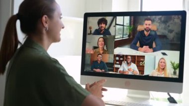 Çevrimiçi toplantının katılımcılarını karşılayan serbest çalışan genç bir kadın, uzaktaki meslektaşlarıyla video konferansı yapıyor, çeşitli takımlara video çağrısı için bilgisayar uygulaması kullanan bir kadının üstünden bakıyor