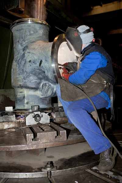 Welder worker is welding a big valve body — Stock Photo, Image