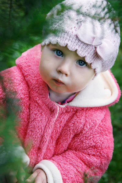 Little baby under blurred branch of green pine — Stock Photo, Image