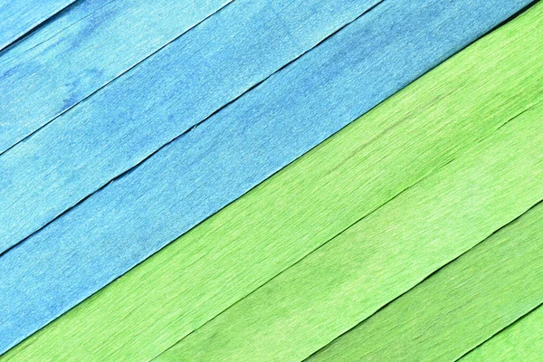 Bright two-tone background from wooden textured planks. Wooden boards painted in blue and green are arranged diagonally and separated into two parts. Colored textured wooden background.