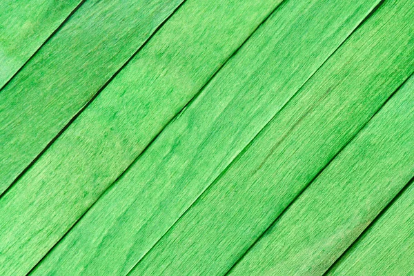 Wooden painted background. Green boards made of wood are arranged diagonally. Textured painted boards. Wooden rustic background or wood grain texture.