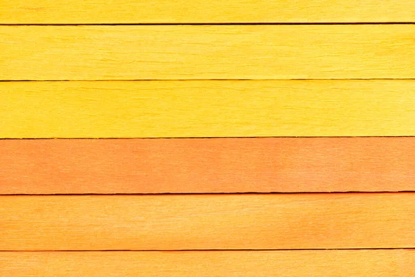 Bicolor background from yellow and orange wooden planks. Wooden textured background with natural patterns. Orange and yellow painted wooden boards arranged horizontally in a row.