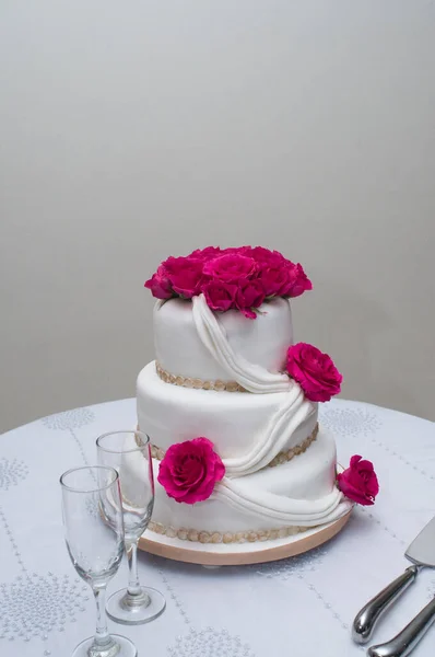 wedding cake with roses with glass cups