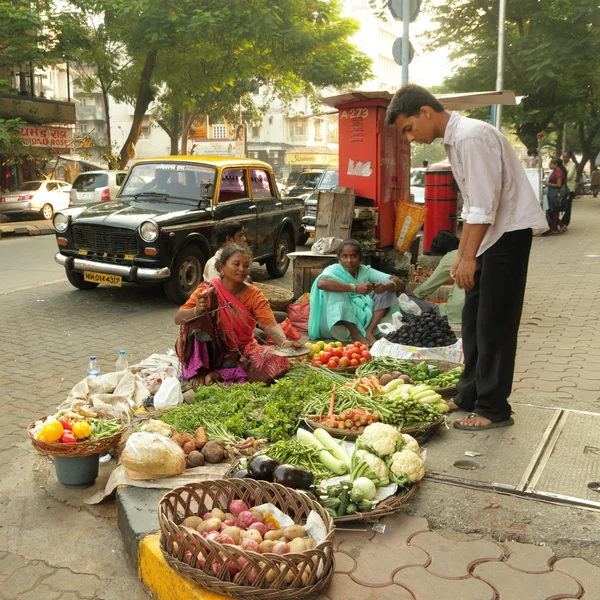 MUMBAI, INDIA - 26 DE NOVIEMBRE: Vendedores no identificados venden bienes en un mercado callejero de verduras el 26 de noviembre de 2010 en Mumbai, India. El sector agrícola representa el 18,1% del PIB. India es el mayor productor de — Foto de Stock