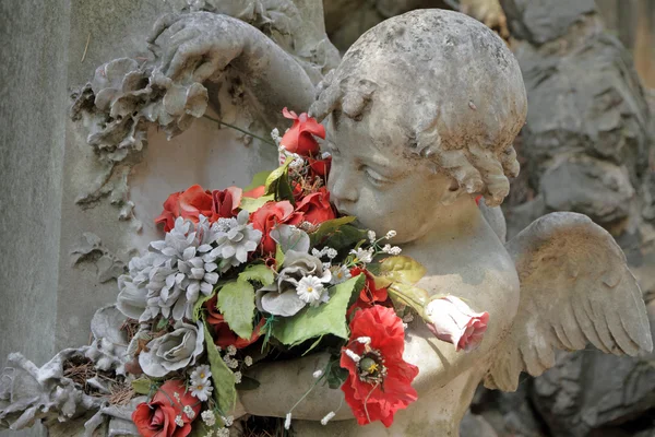 Escultura angélica com flores — Fotografia de Stock