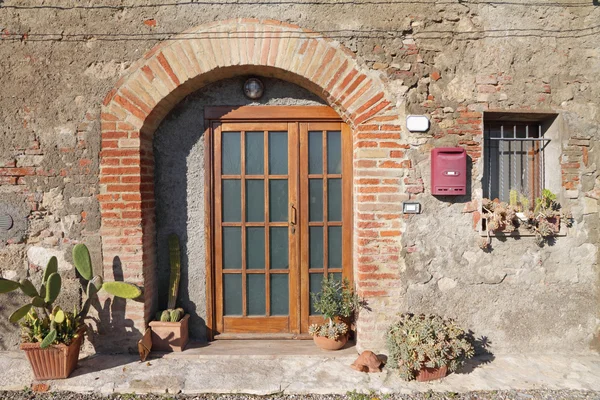 Μπροστινή πόρτα διακοσμημένα με εγκαταστάσεις κάκτων στο Τοσκάνης χωριό, Ιταλία — Φωτογραφία Αρχείου