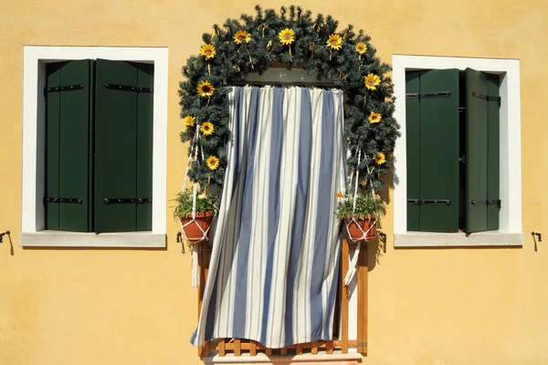 Söt dörröppningen inramad med garland krans och randig dörrgardin — Stockfoto