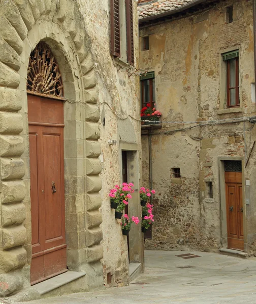 Beautiful old arch doorway on tuscan narrow street in small town — Stockfoto