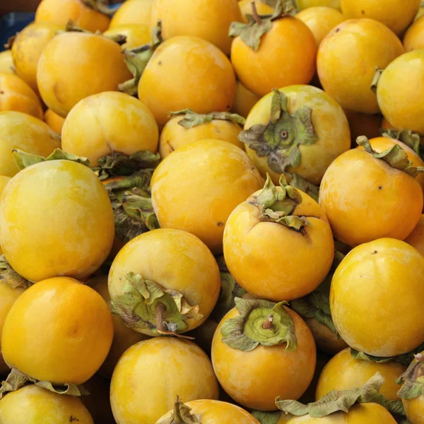 Viele persimona-früchte als hintergrund, bild vom toskanischen markt sa — Stockfoto
