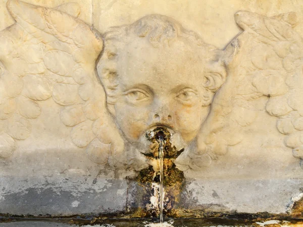 Gamla offentliga dricka vattenkälla med änglalika dekoration — Stockfoto