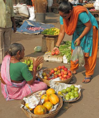 Satıcı bir sokak pazarında meyve satıyor.