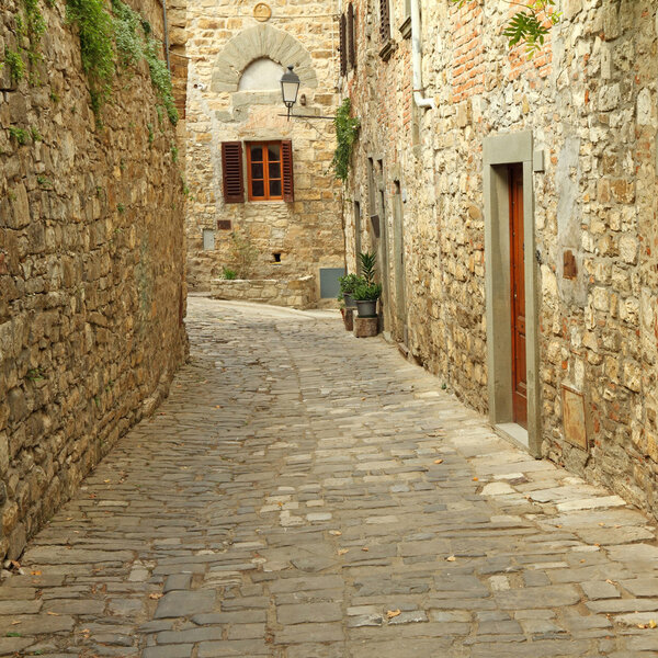 Narrow paved street and stone walls in italian village, Montefioralle, Tuscany, Italy, Europe