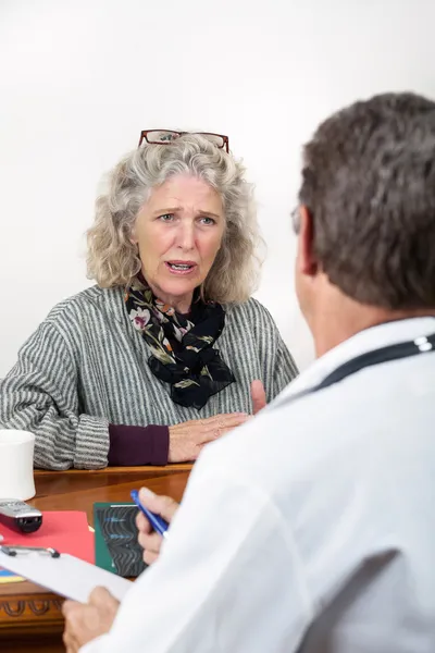 Mulher preocupada conversando com seu médico — Fotografia de Stock
