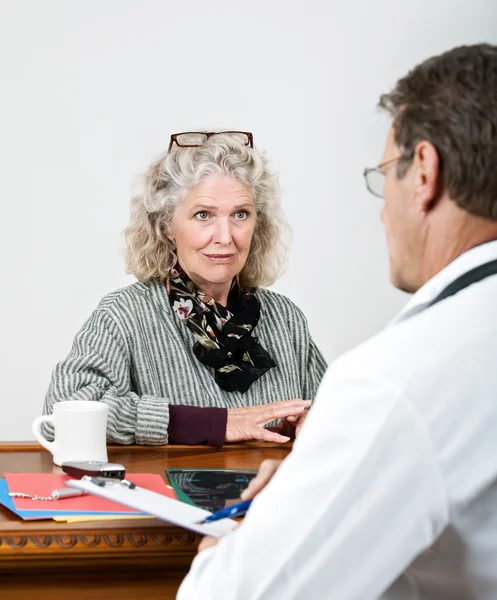 Mujer madura escuchando a su médico — Foto de Stock