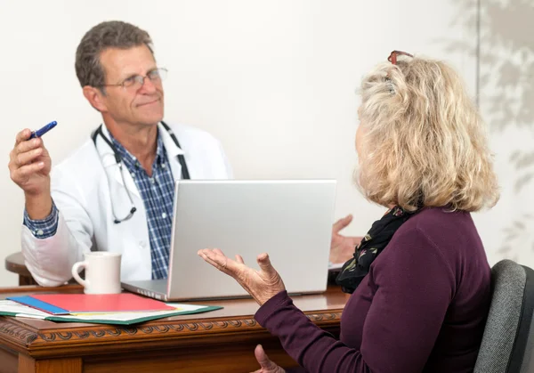 Erkek doktor ve Bayan hasta tıbbi tedaviler tartışmak — Stok fotoğraf