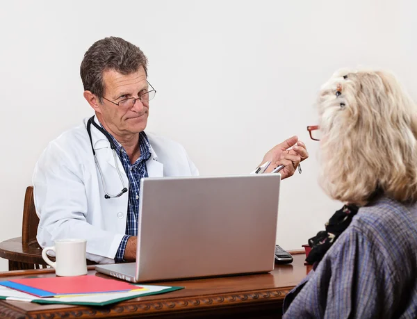 Несимпатичный доктор прислушивается к пациентке — стоковое фото