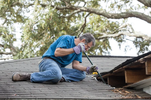 Homem reparando telhado de vazamento — Fotografia de Stock