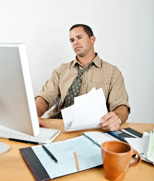 Müder junger Mann am Schreibtisch, der Rechnungen bezahlt — Stockfoto