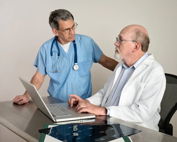 Médicos Seniores discutindo pacientes MRI Film Scans — Fotografia de Stock