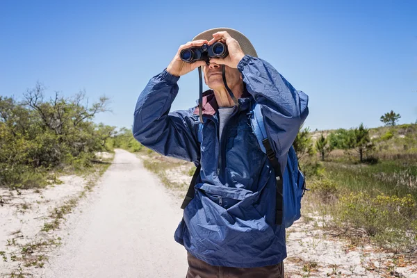 Muž turistiku a pozorování ptactva a při pohledu dalekohledem — Stock fotografie