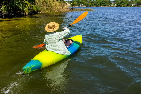 Maduro mujer disfruta pacífico remando en su kayak —  Fotos de Stock