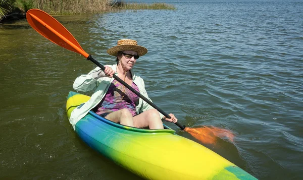 Maduro mujer disfruta pacífico remando en su kayak —  Fotos de Stock