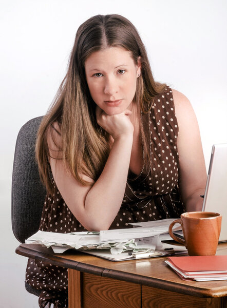 Confident Serious Looking Pregnant Woman with Stack of Unpaid Bills Sitting at Desk