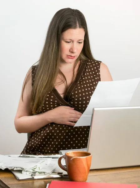 Giovane donna incinta si preoccupa lettura estratti conto bancari e bollette scadute — Foto Stock