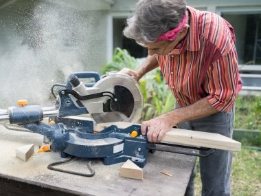 Man Sawing Wood with Sliding Compound Miter Saw clipart