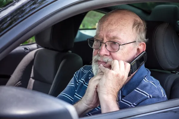 Rädda äldre man i bil på mobiltelefon — Stockfoto