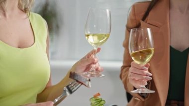 Arkadaşların partisi, genç kız arkadaşların kadehleri kadehlerle tokuşturması keyifli bir toplantı sırasında yemek odasında oturmak.